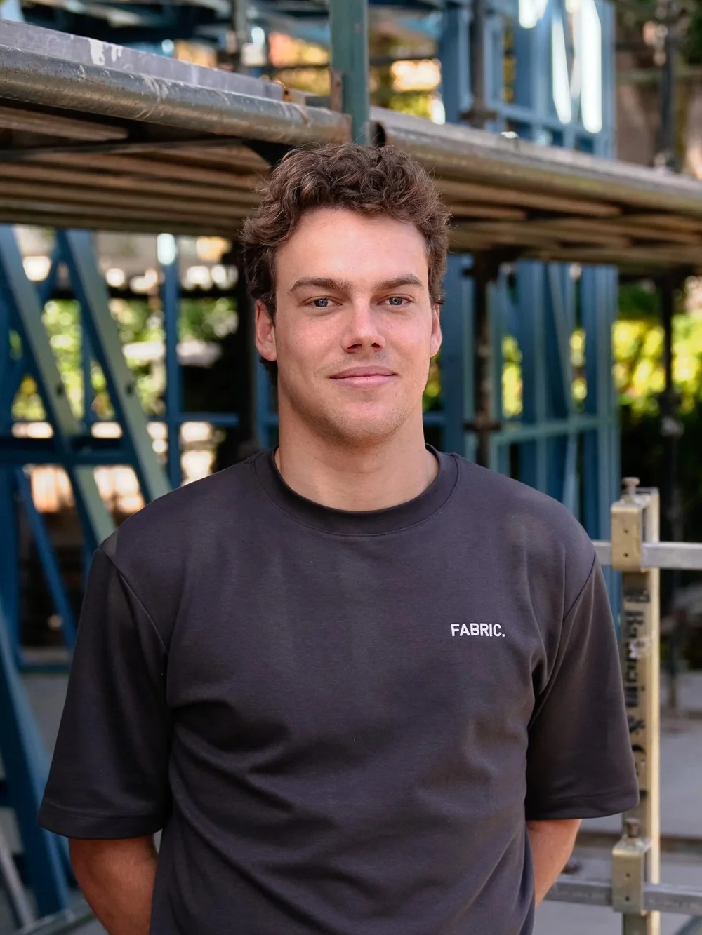 Man in black Fabric shirt at construction site, scaffolding background.