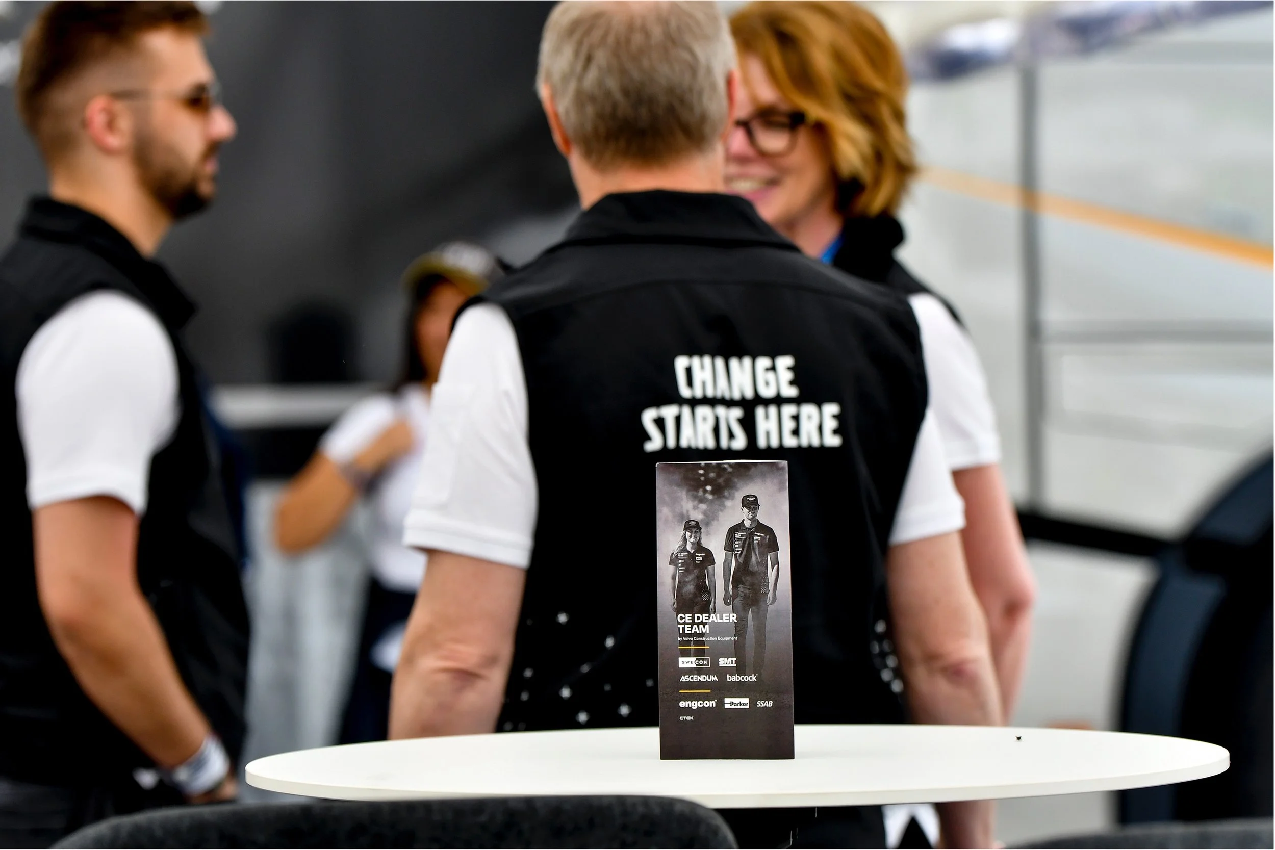 Personer i Volvo CE-kläder står utomhus vid ett evenemang