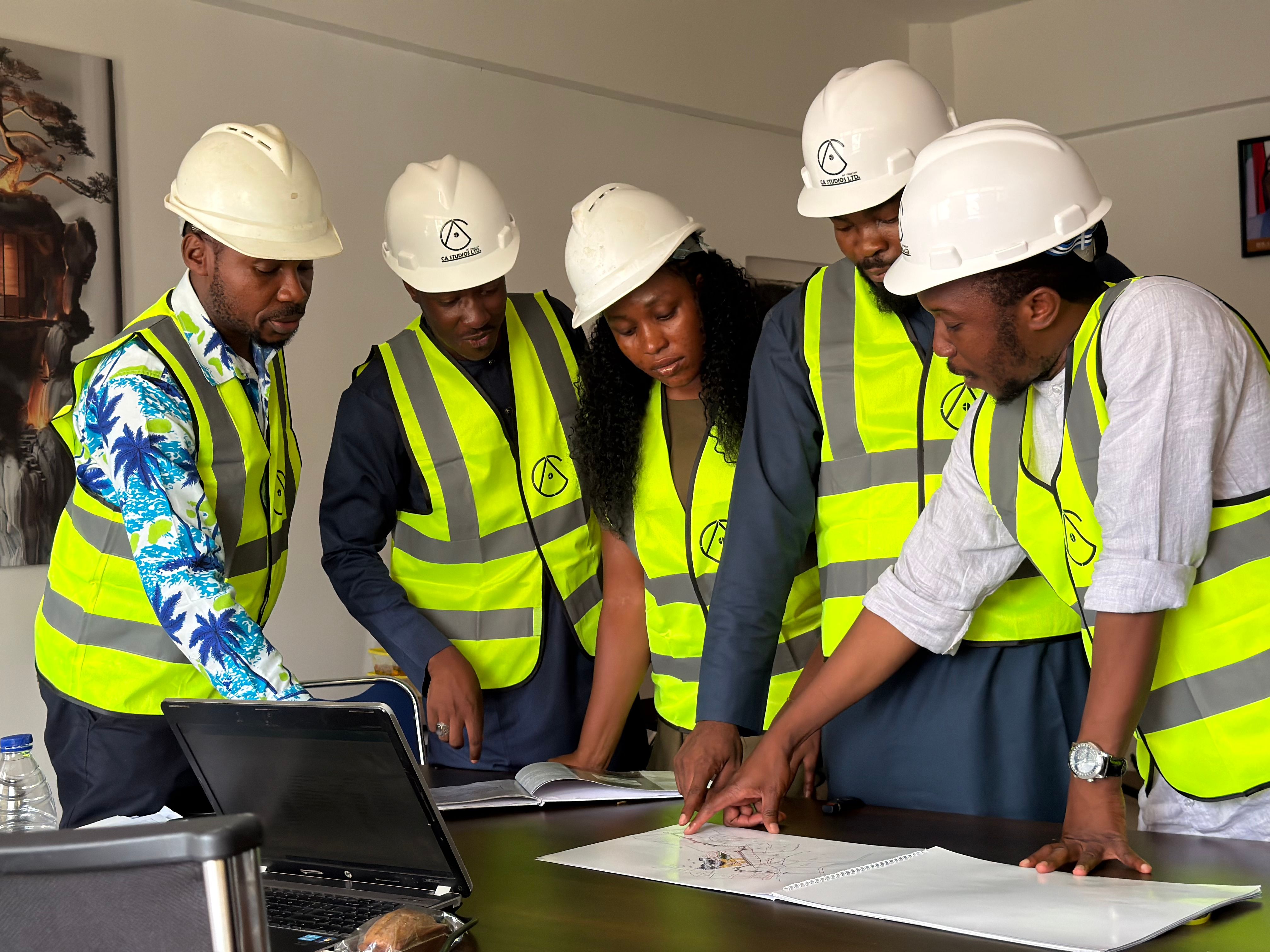 group-of-engineers-in-safety-gear-reviewing-blueprints-indoors. - harrun-muhammad (pexels)