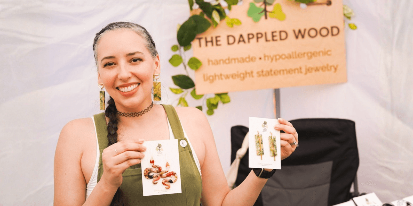 "A woman displays colorful, handmade Flora flower earrings by The Dappled Wood, showcasing nature-inspired, lightweight statement jewelry.