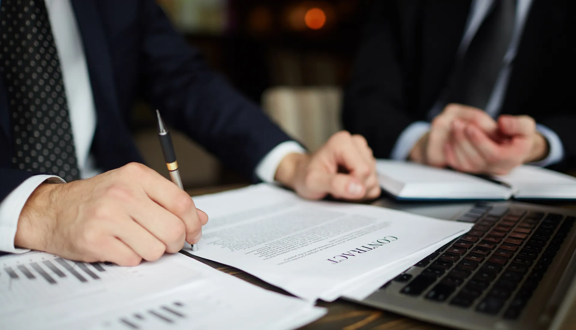 a notebook with a pen on top of a wooden table