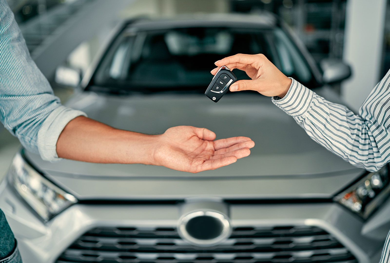Zwei Arme wo einer ein Autoschlüssel an Kulxpert abgibt nach Autoverkauf an Kulxpert