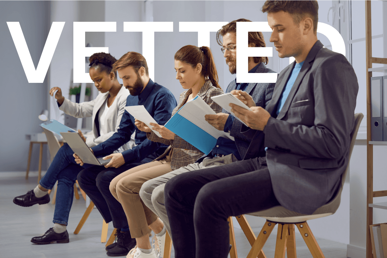 A group of people sitting in a meeting or discussion, with the word "VETTED" prominently displayed in the background.