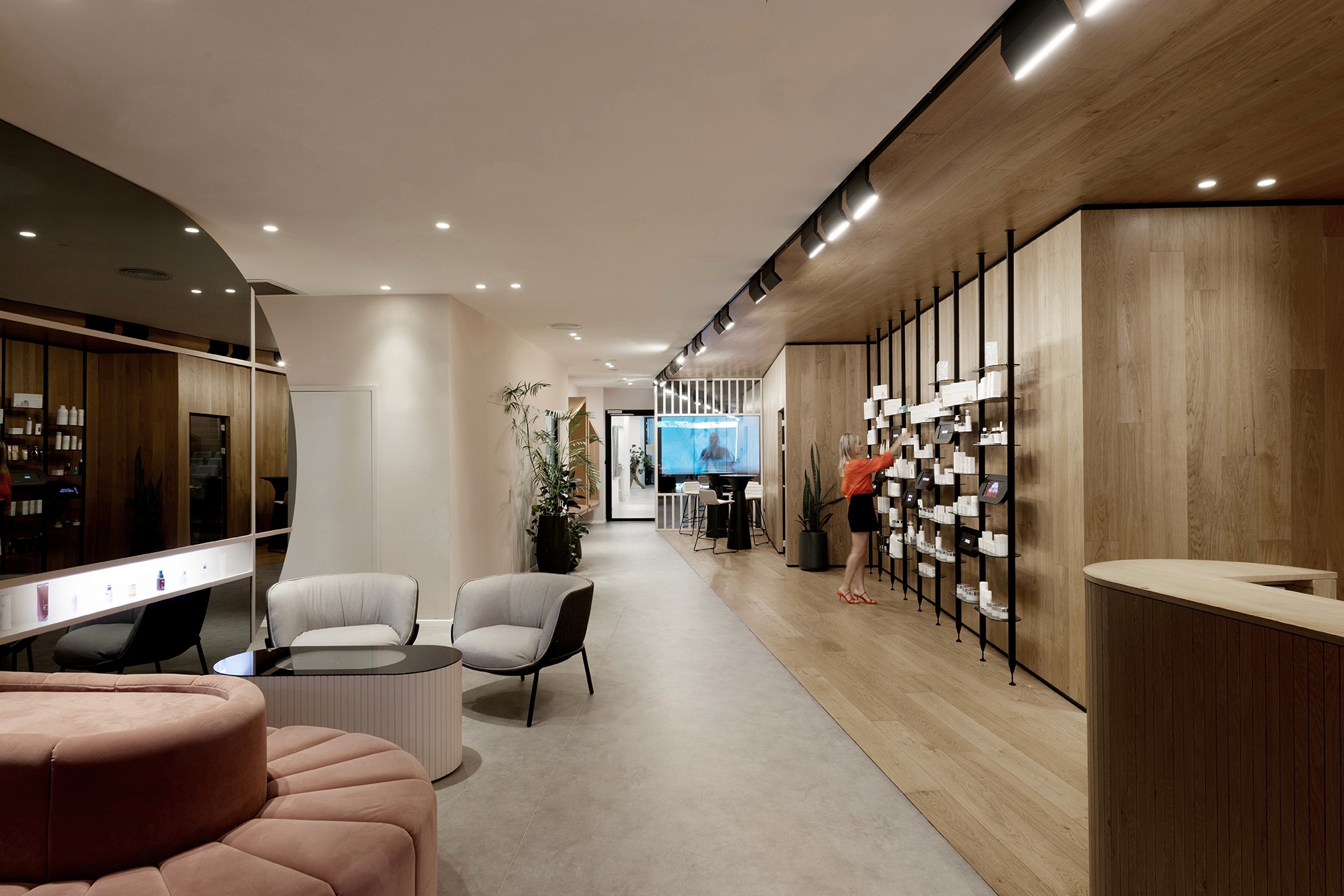 אזור קבלה מעוצב עם חיפויי עץ טבעיים וספה ורודה מעוגלת