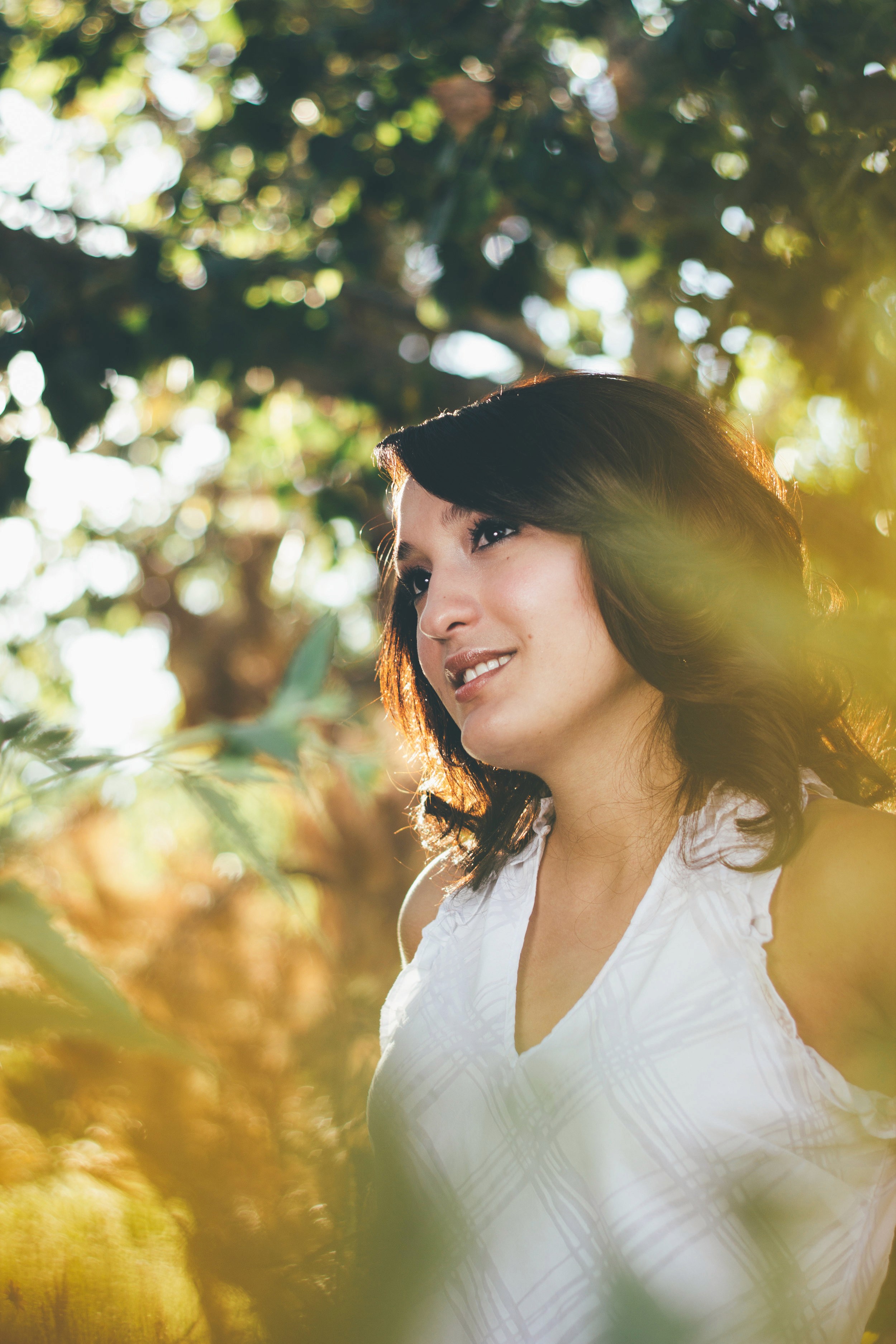 Smiling portrait in dappled golden-hour forest light