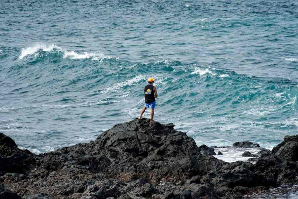 Man standing on rocks and fishing in the sea, Jeju