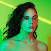 Dafne Keen against a green background with green lighting