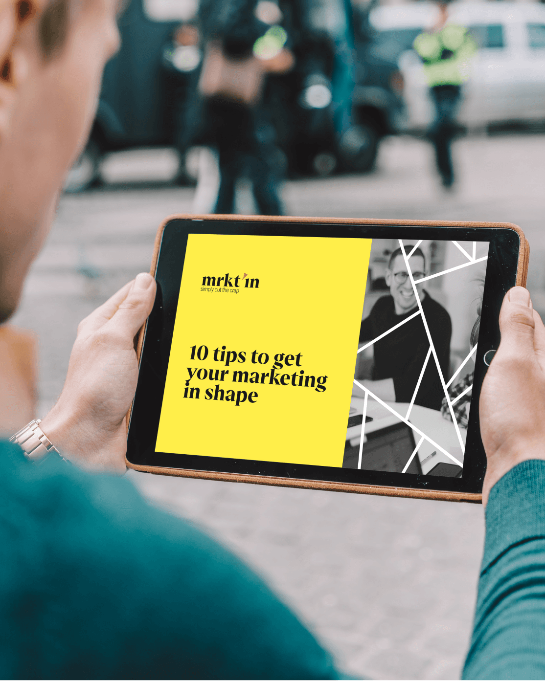 Man holding ipad with website on screen.