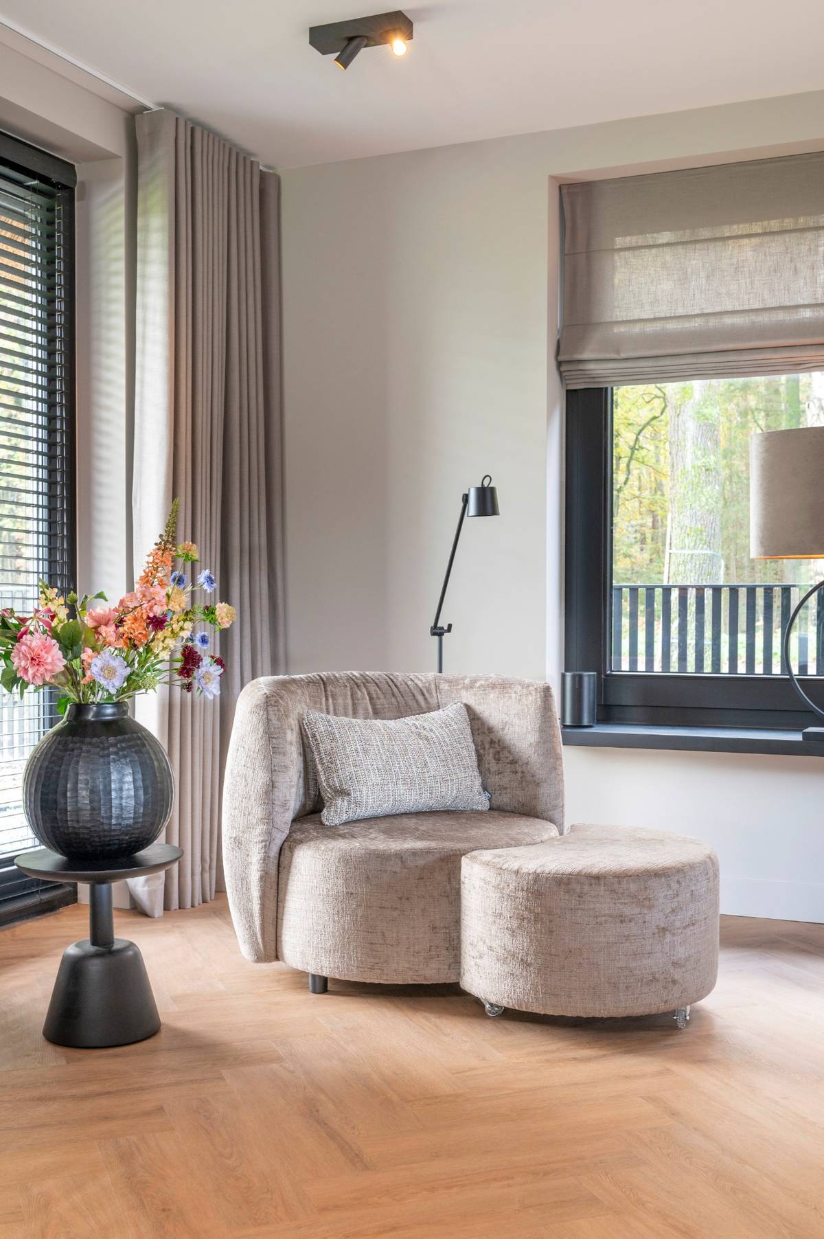 zitje landelijke villa met ronde fauteuil en poef, neutrale kleuren