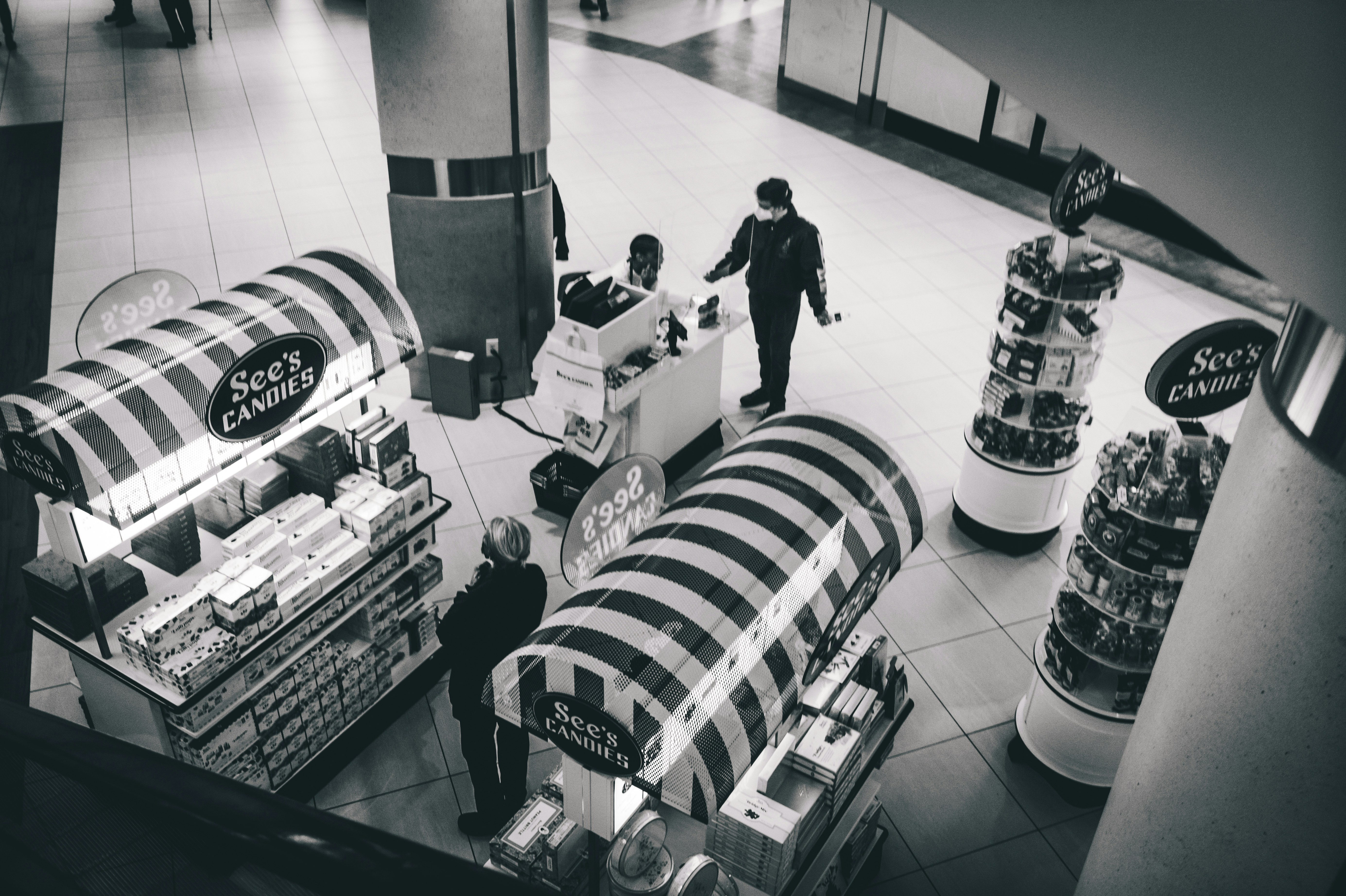 a black and white photo of people shopping in a store