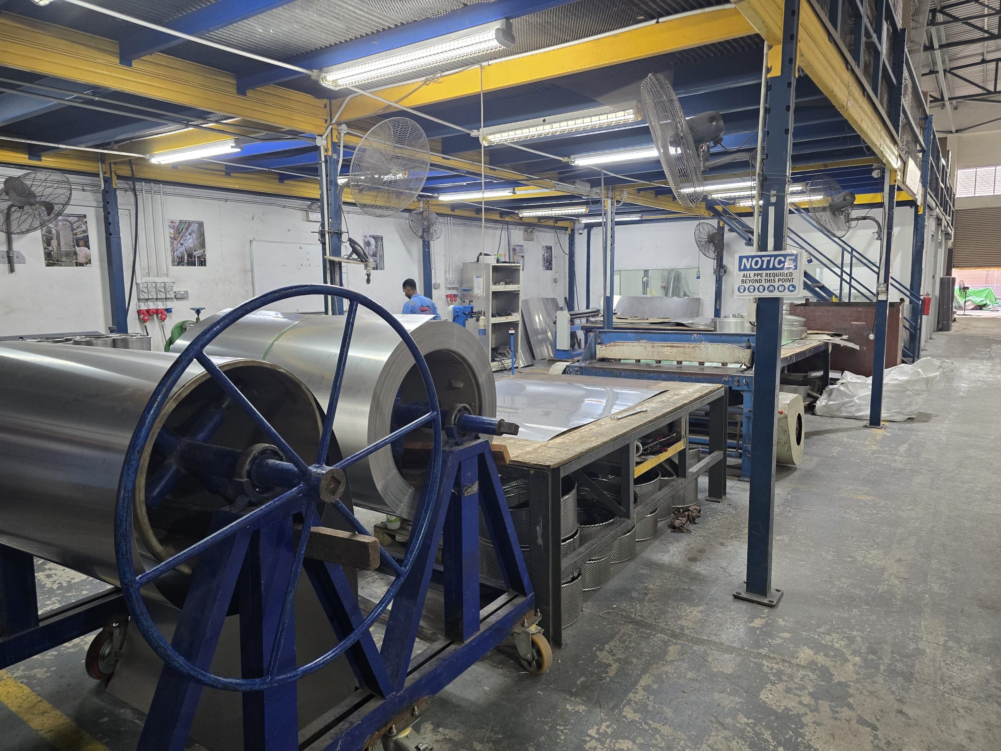Large industrial fabrication workshop with metal structures and workers
