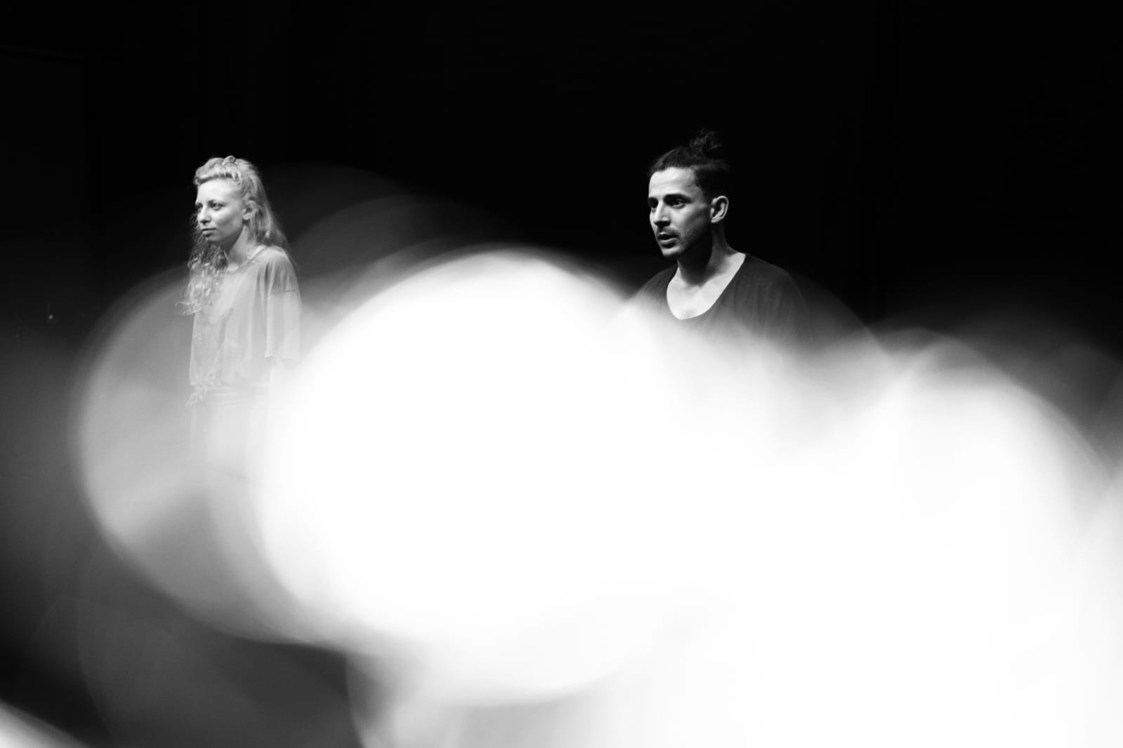Woman in pink leather jacket crouching outdoors at night