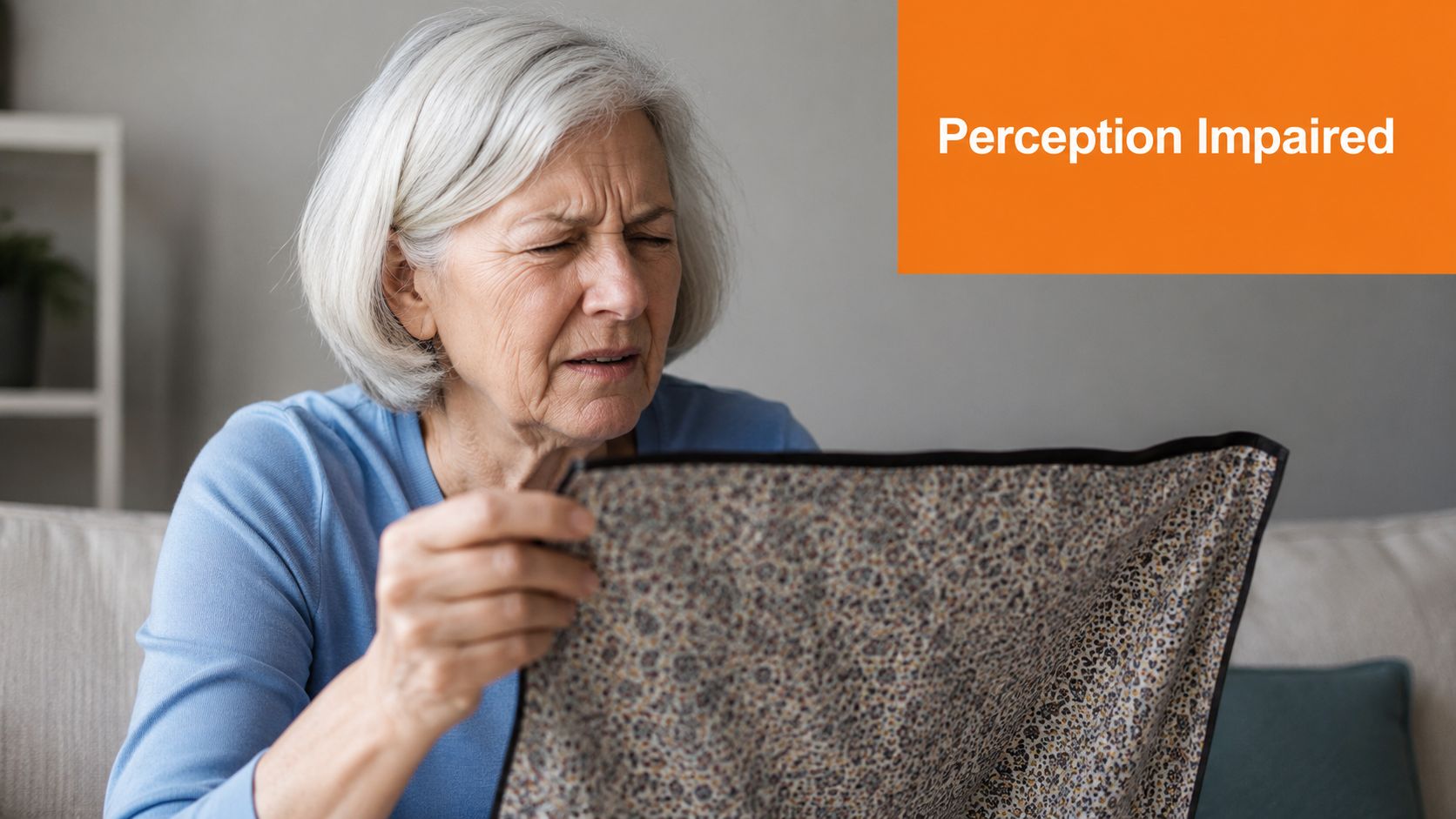 An elderly woman with grey hair appearing confused or distressed while looking at a patterned fabric.