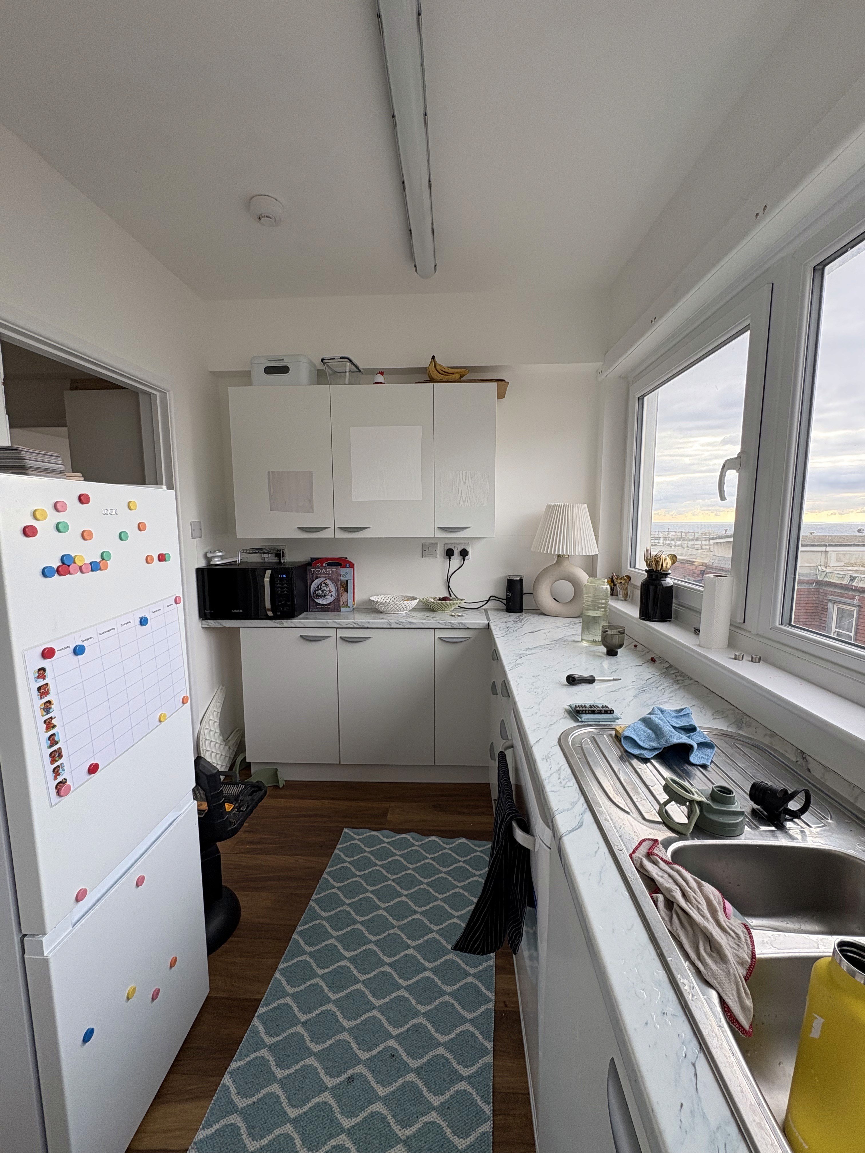 Before: compact kitchen with standard white units and limited storage