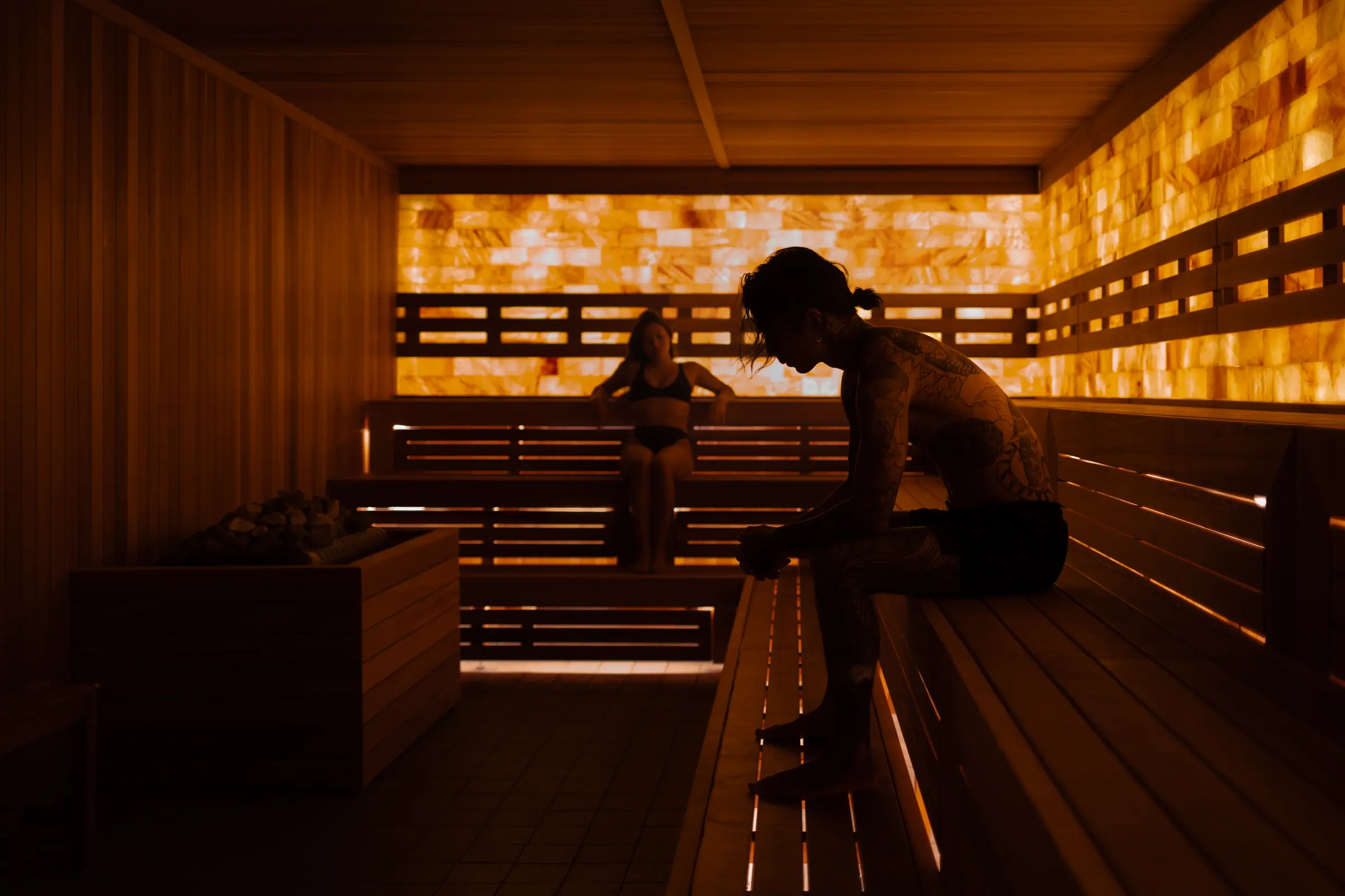 Participants seated in a sauna during an Aufguss ceremony, where guided timing and positioning are used to control heat and steam distribution.