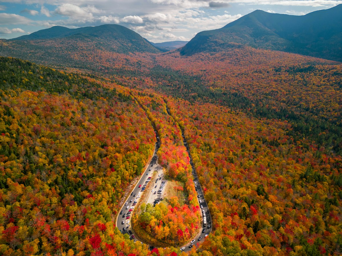 Aerial view of the Kancamagus Highway curving through New Hampshire fall foliage in the White Mountains
