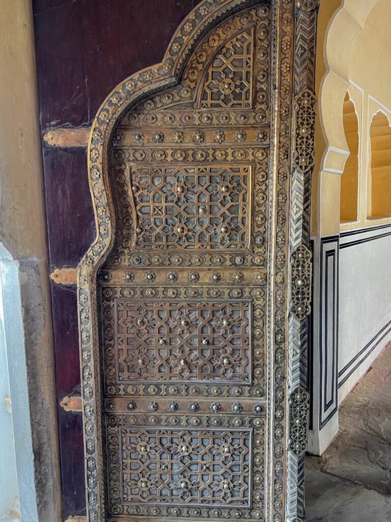 An intricately carved wood and metal door in Hawa Mahal, Jaipur which depicts the Mahal's grandeur.