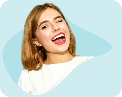 A cheerful woman winking and showing her bright smile, symbolizing confidence and satisfaction with dental care.