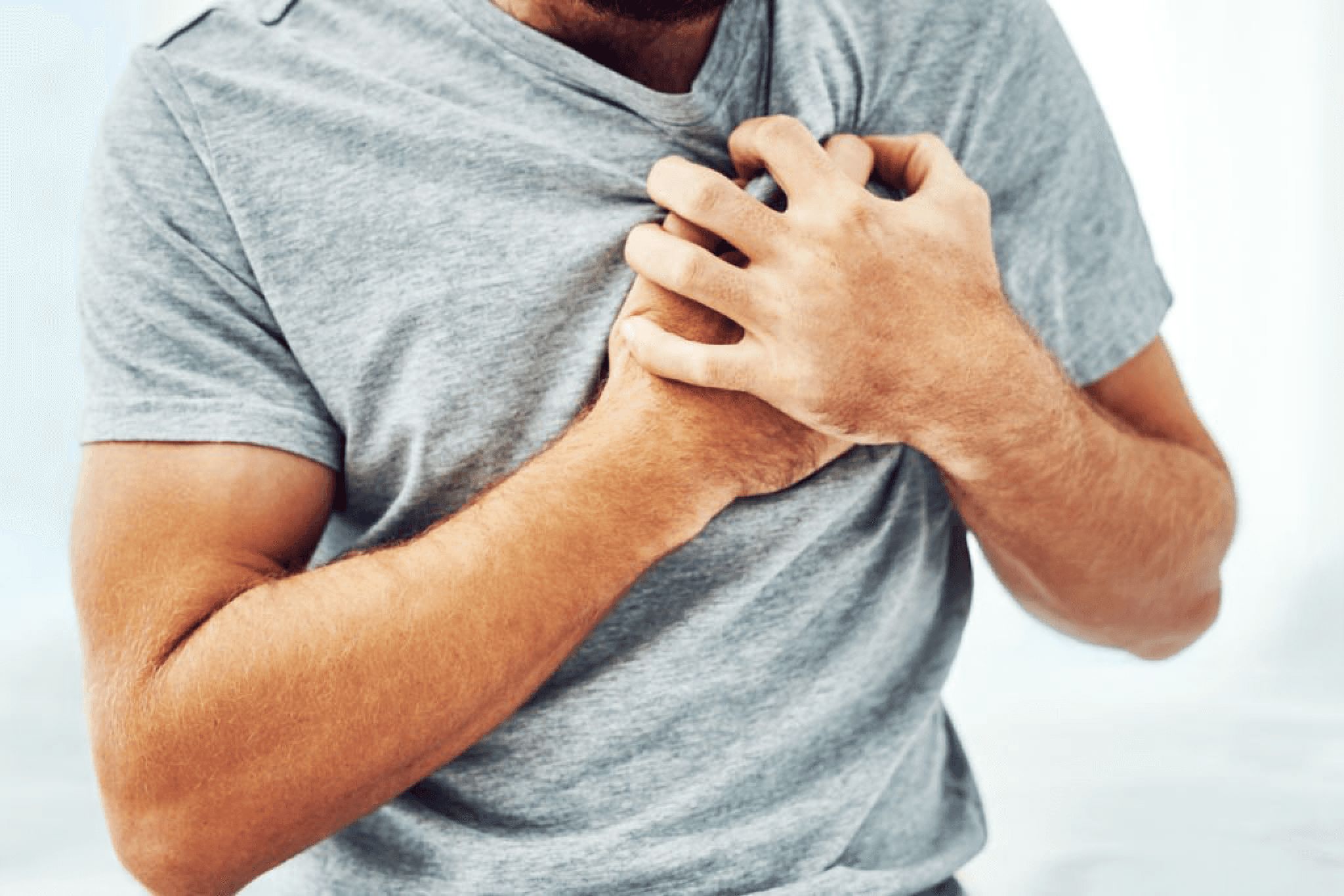 Man experiencing chest pain symbolizing heart health issues and the risks of cardiovascular conditions.