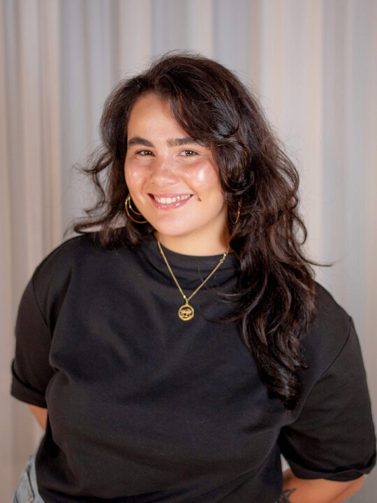 A person smiling and pointing at a screen.