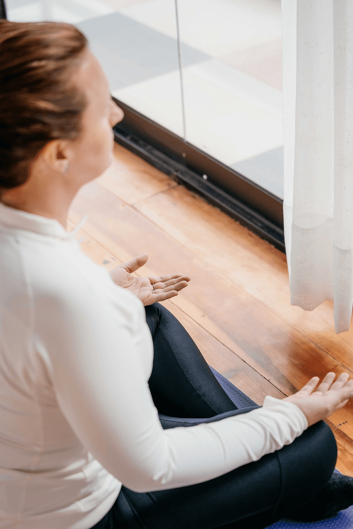 Aerial view of a winding road surrounded by dense green and yellow trees, showcasing nature’s vibrant colors.