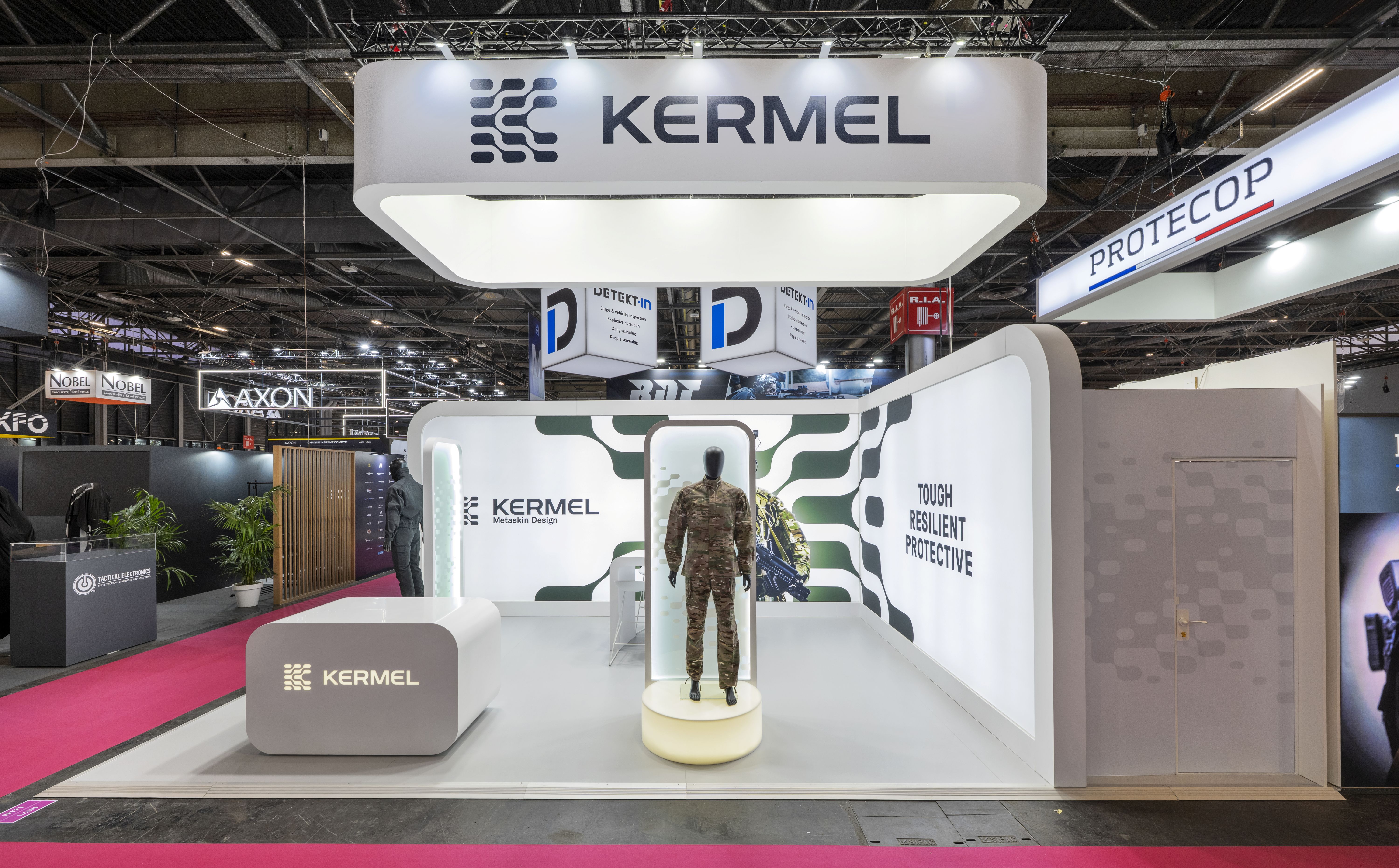 Stand KERMEL Milipol Paris 2025 – aménagement stand sur-mesure blanc et vert avec totem mannequin protection, réalisé par Expace