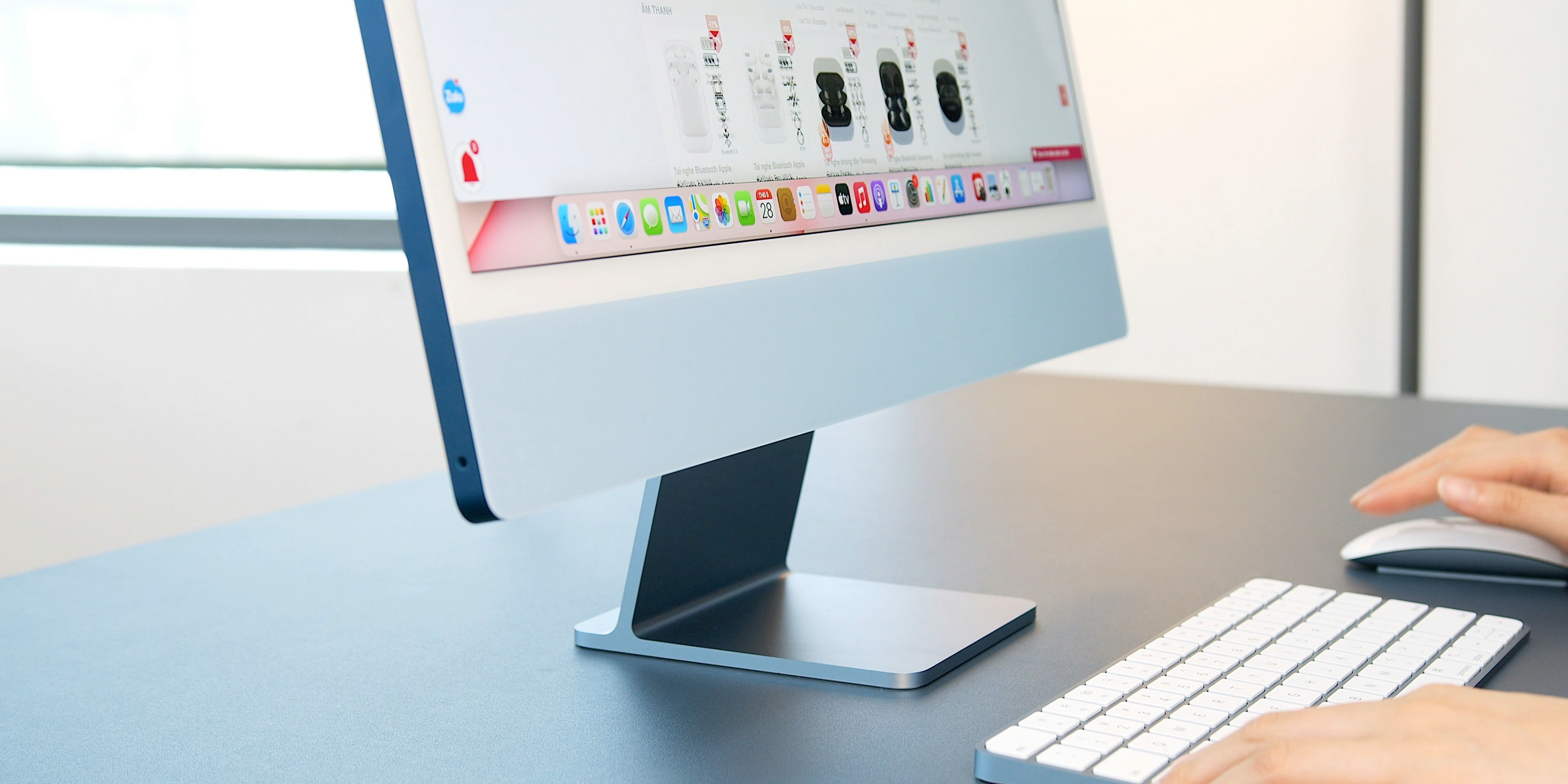 A computer screen displays a gallery with a keyboard and mouse on a desk.