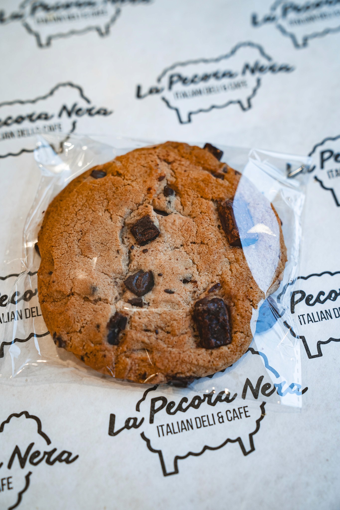 a glass of cocktail with a slime orange fruit