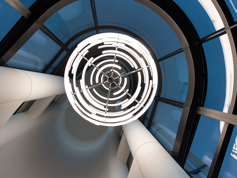 View from beneath the Deloitte Orb installation, highlighting the geometric arrangement of curved acrylic profiles and integrated LED lighting.