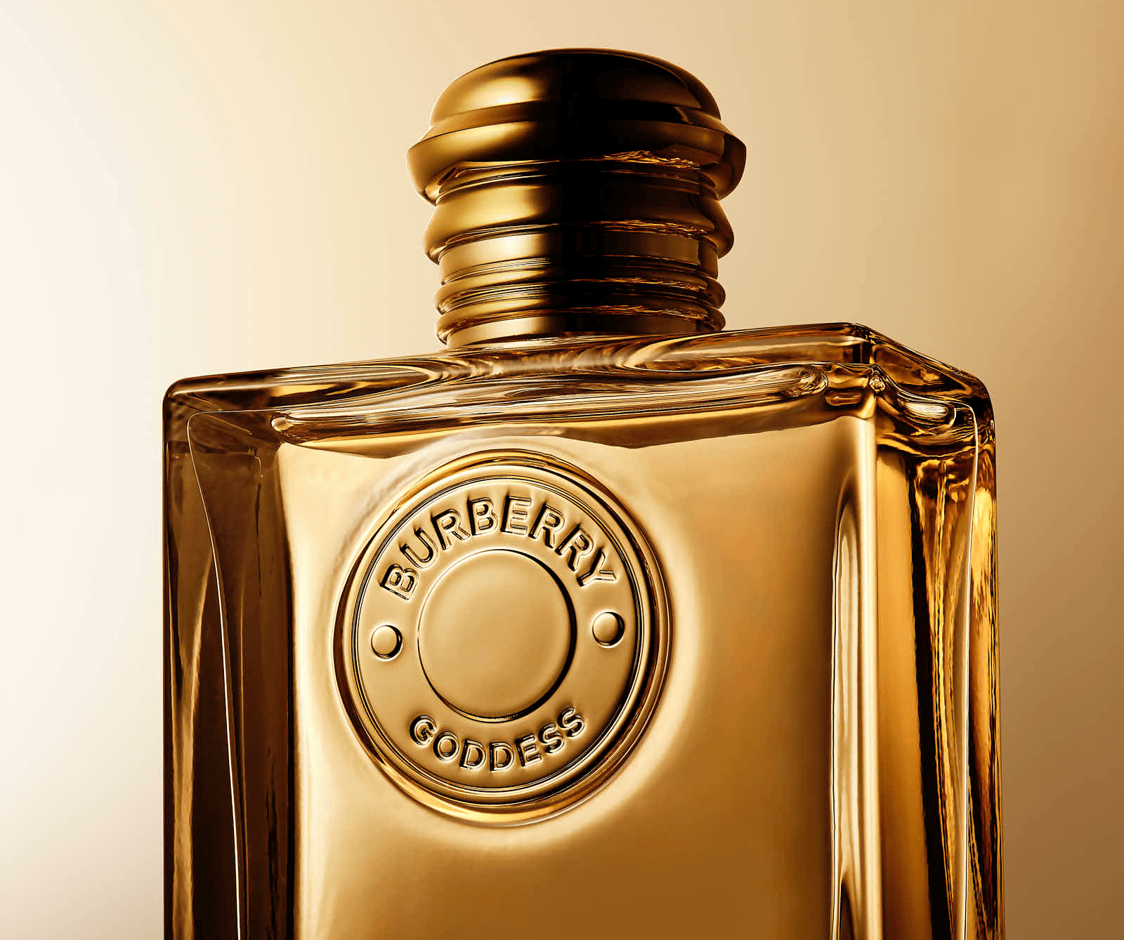 A close-up of a glass perfume bottle with a golden liquid and decorative label, set against a warm background.