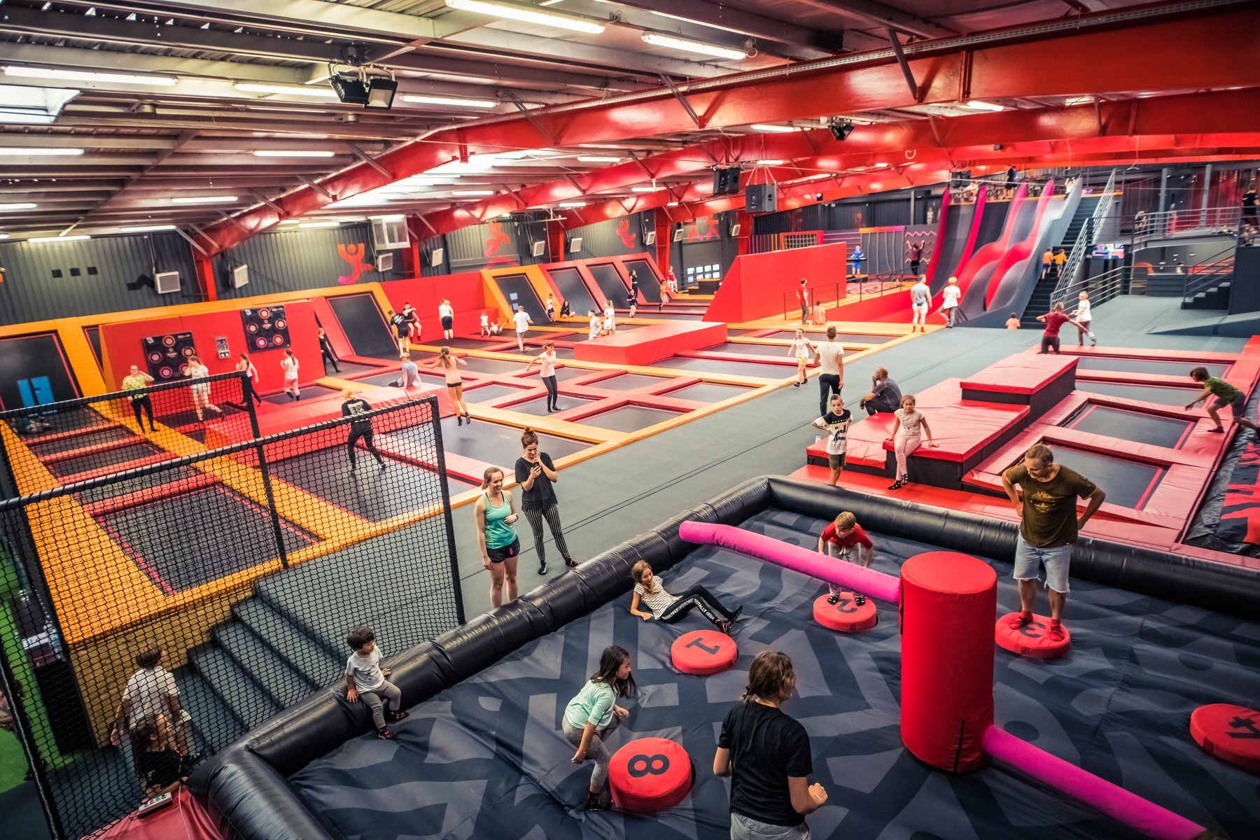 Ludzie bawiący się w parku trampolin, którzy weszli dzięki systemowi Going. Places, który umożliwia sprzedaż biletów, napojów, przekąsek, merchandisingu oraz zakup voucherów