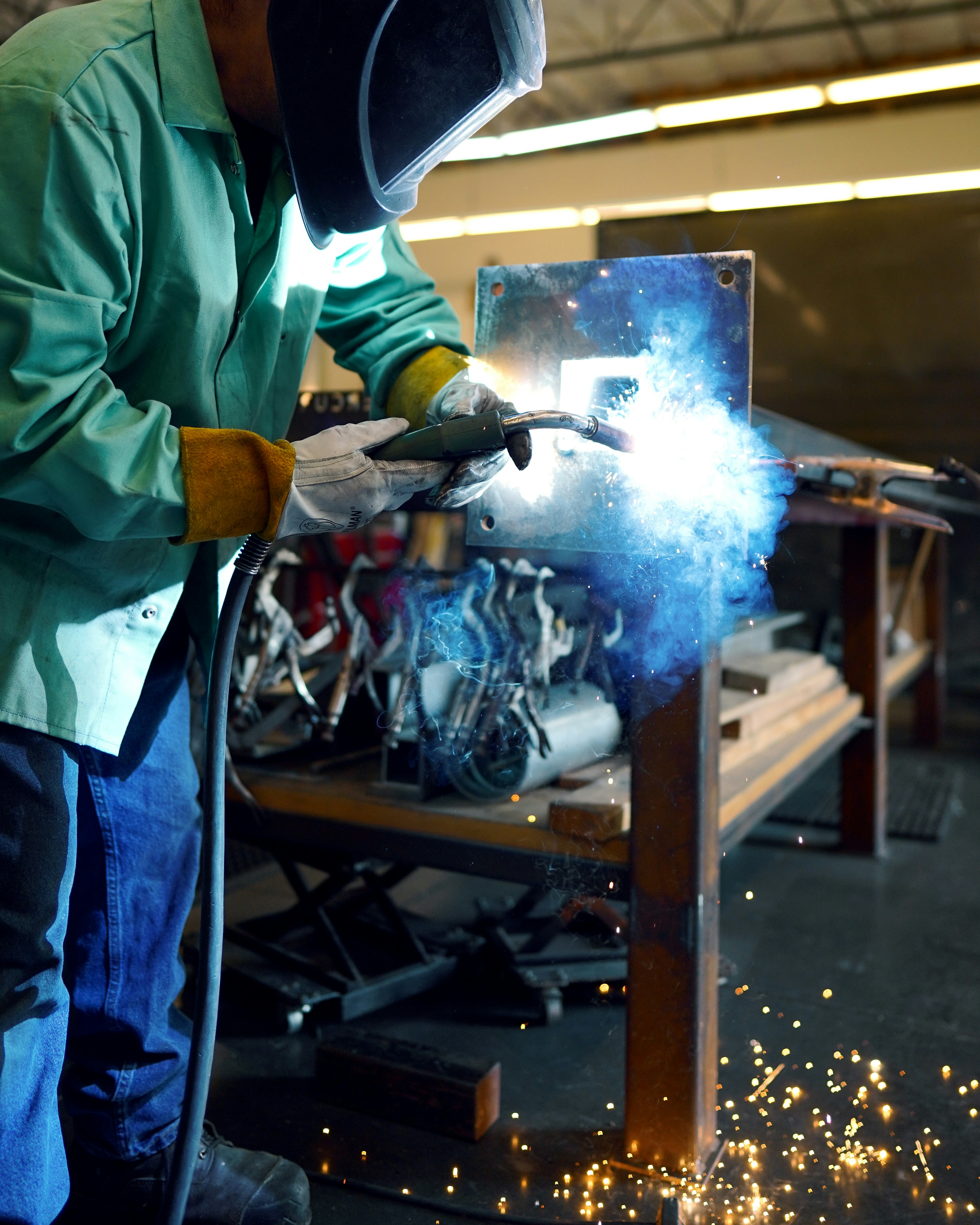 Man welding on recycled steel for a project for a client.