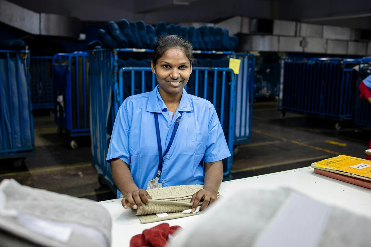 Housekeeping staff member smiling in a resort service area.