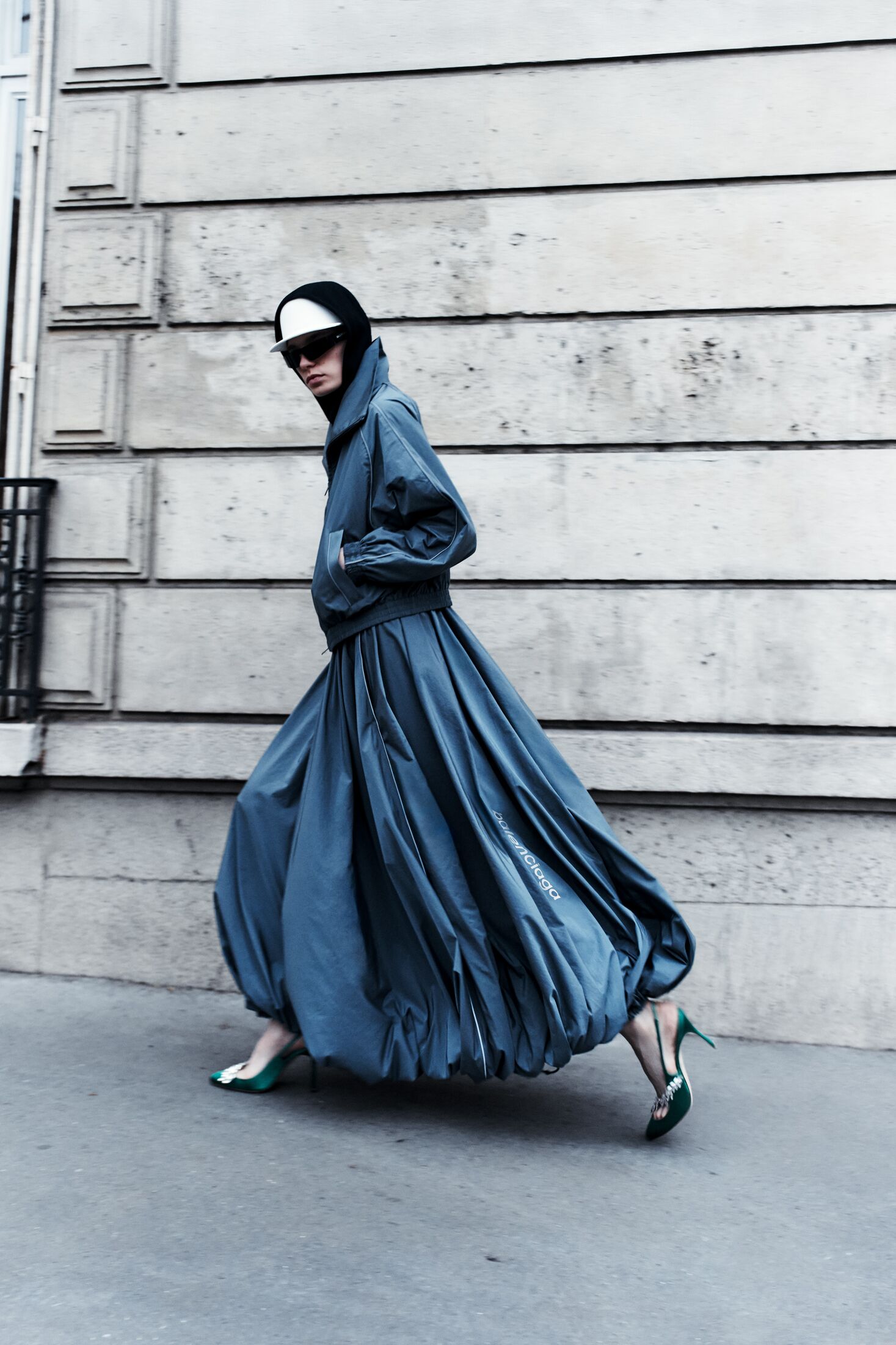 View of the French countryside through a stone villa’s open living room, with sofas and trees framing the scene