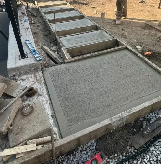 “Concrete sidewalk installation in progress by Falcons Landscaping.”