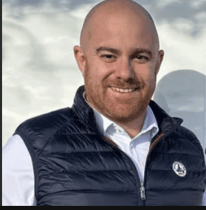 a man with a goatee smiles at the camera