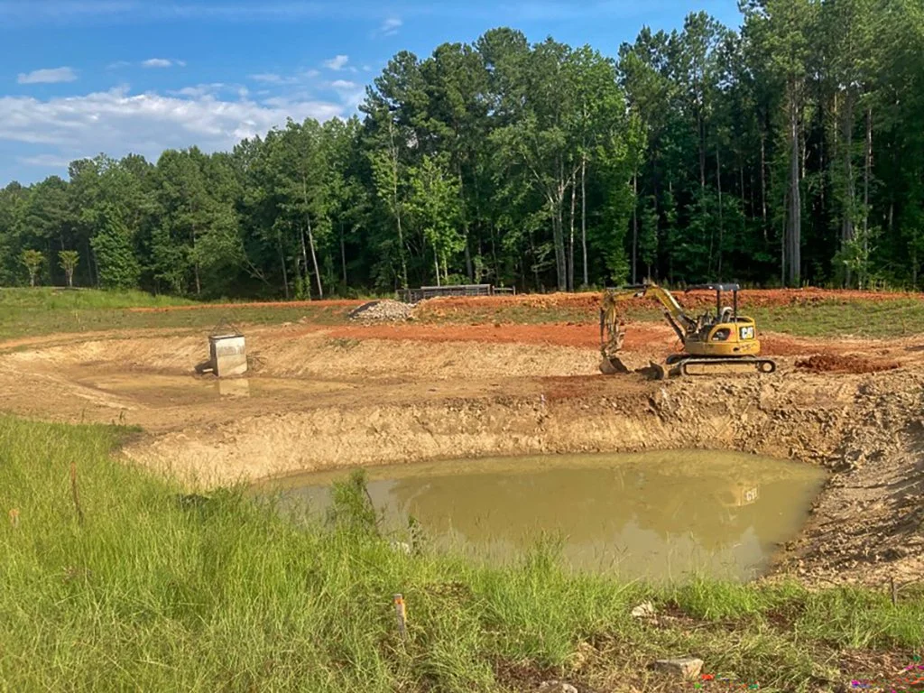 Pond construction site showing excavation, berm shaping, and grading in Kansas City