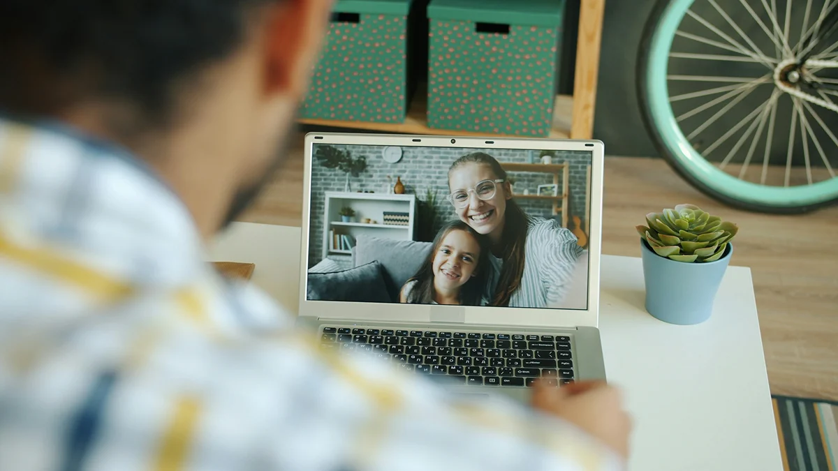 A man joining a video call with two people on a laptop.