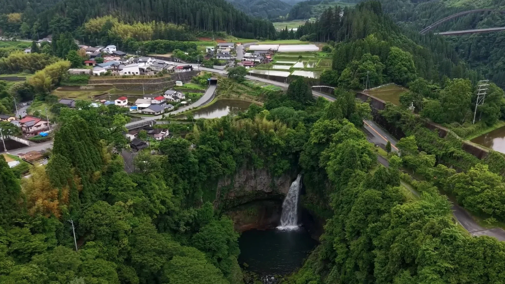 Aerial view of the village, a waterfall and terraced fields around Kurokawa Onsen