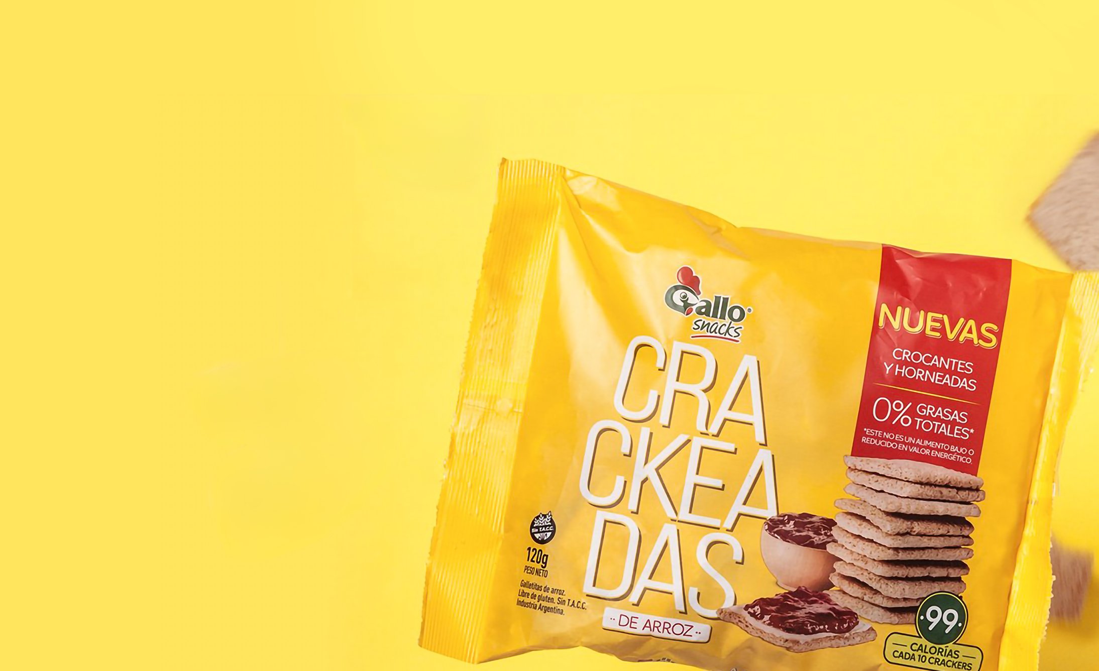 Yellow packaging of Gallo Snacks rice crackers on a matching yellow background. The label highlights "0% grasas" with an image of stacked crackers.