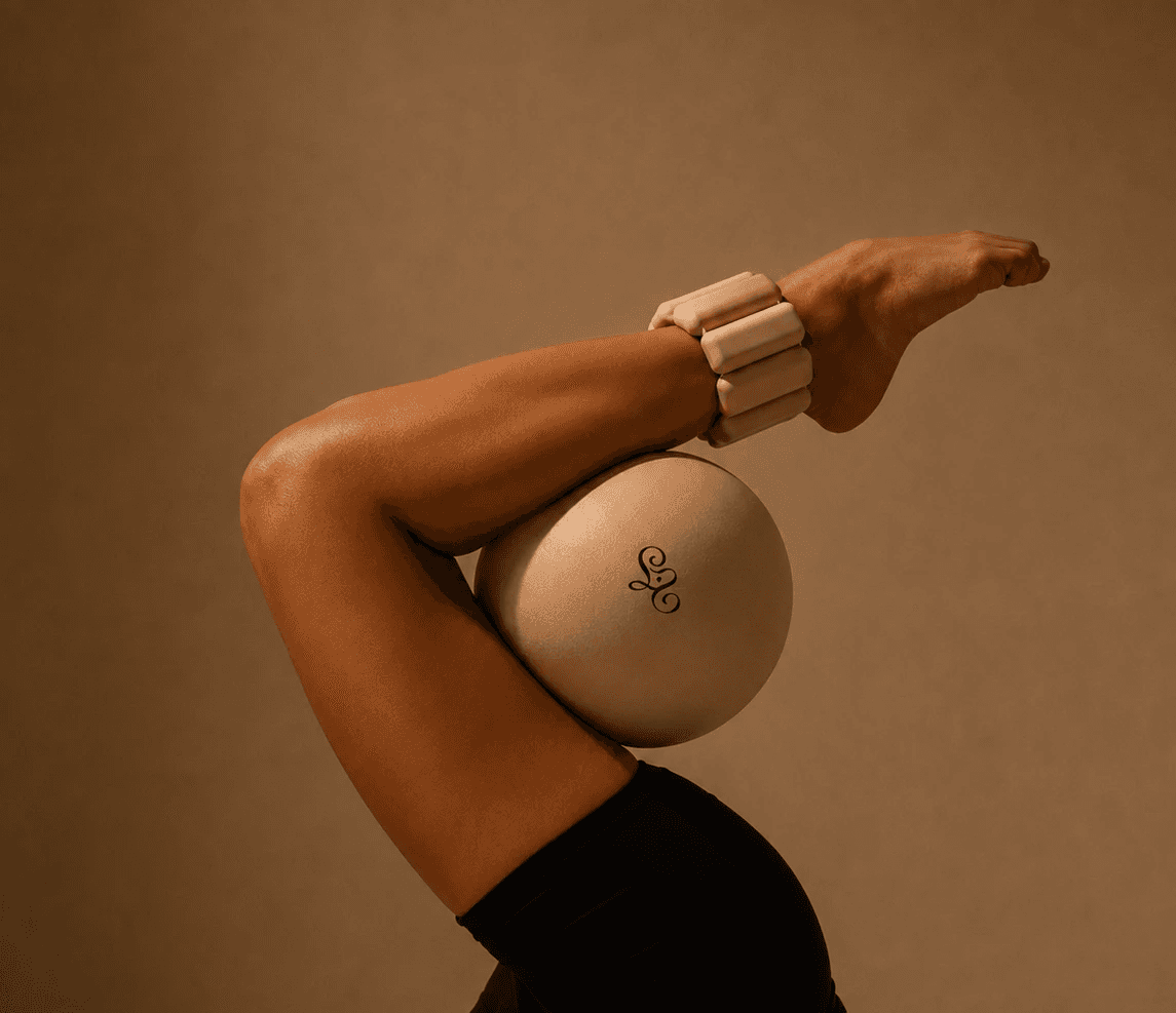 Pilates participant stretching with a small exercise ball