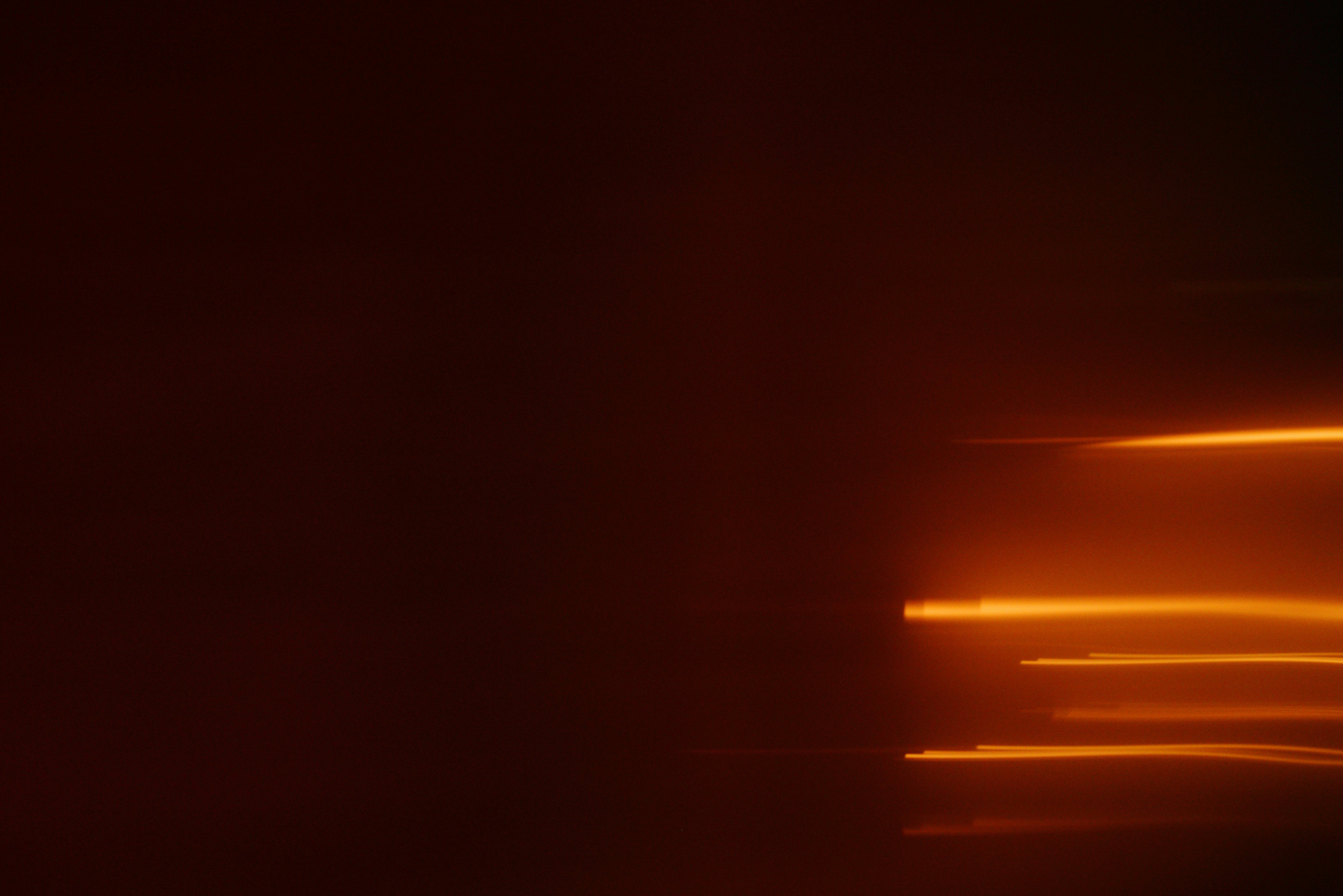 Abstract streaks of orange light on dark background