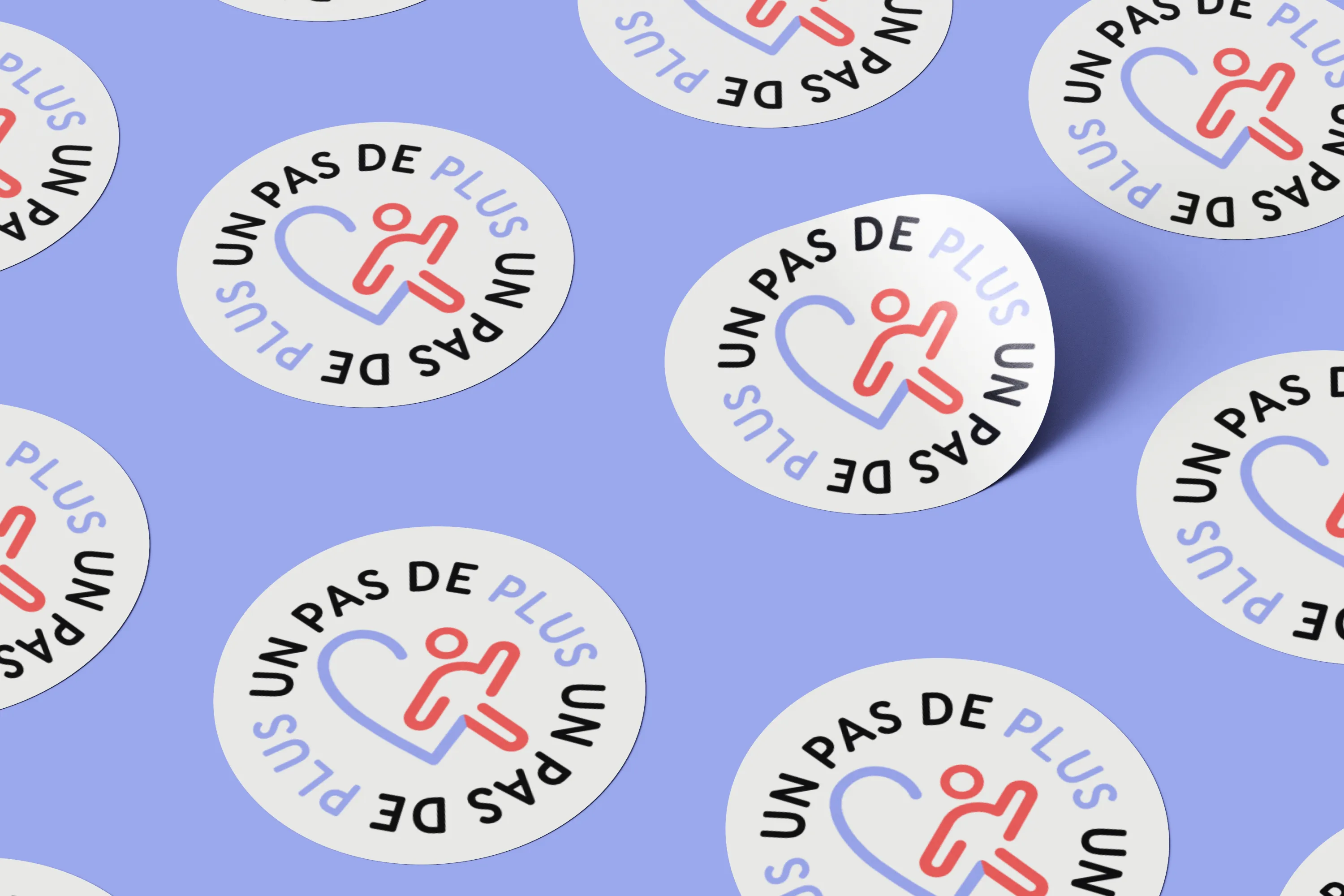 Mockup de stickers ronds sur lesquels figure la variation du logo de l'association Un Pas de Plus.