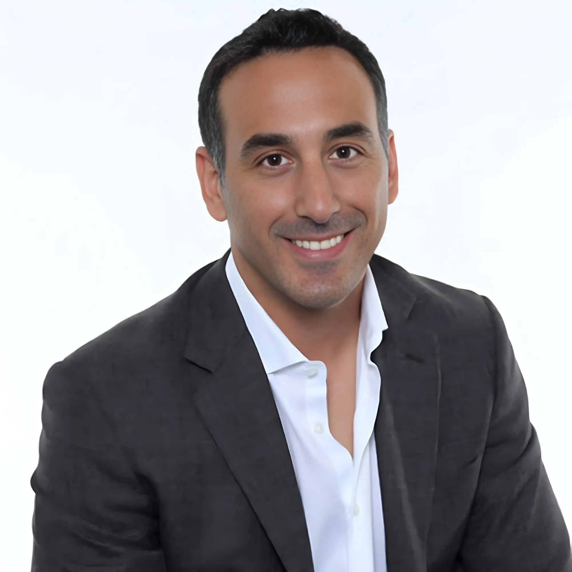 Mike Pusateri, Bent Pixels, smiling in a black suit against a white background.