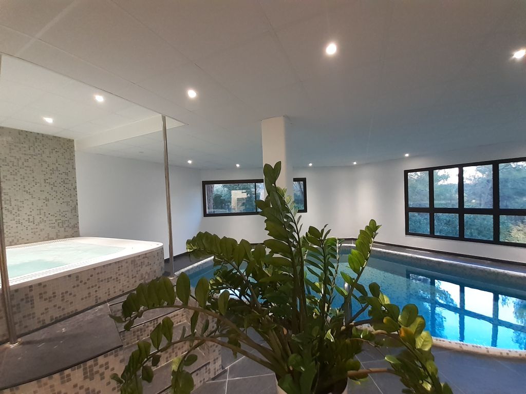 Interior spa or wellness area with pool or water feature, modern white ceiling with skylights, and contemporary design