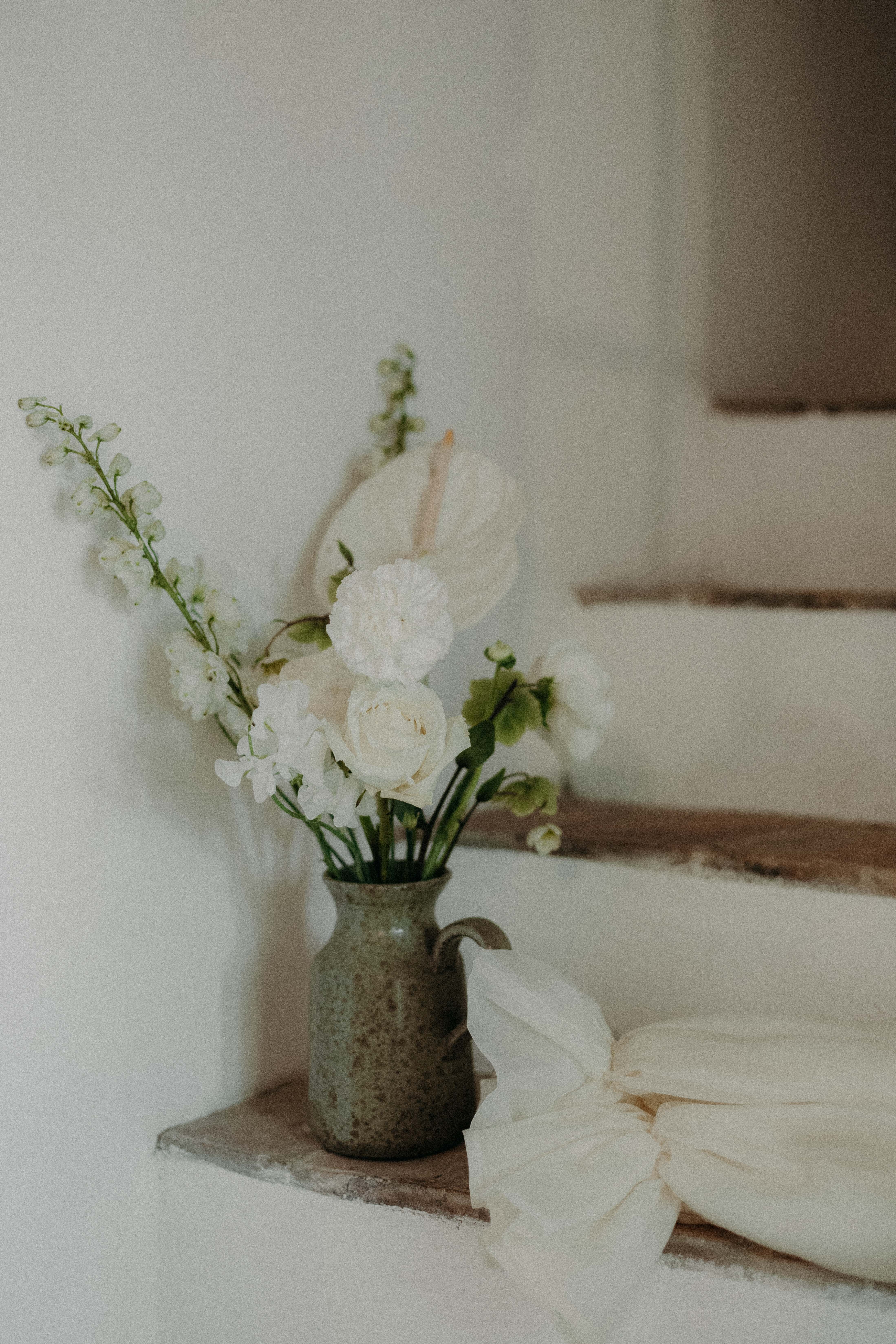 A bride in a lace wedding dress gently holds.