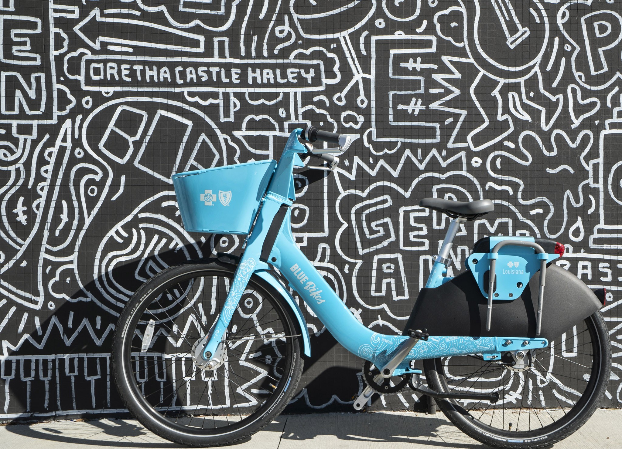 Blue Bike branded bike in front of illustrated wall