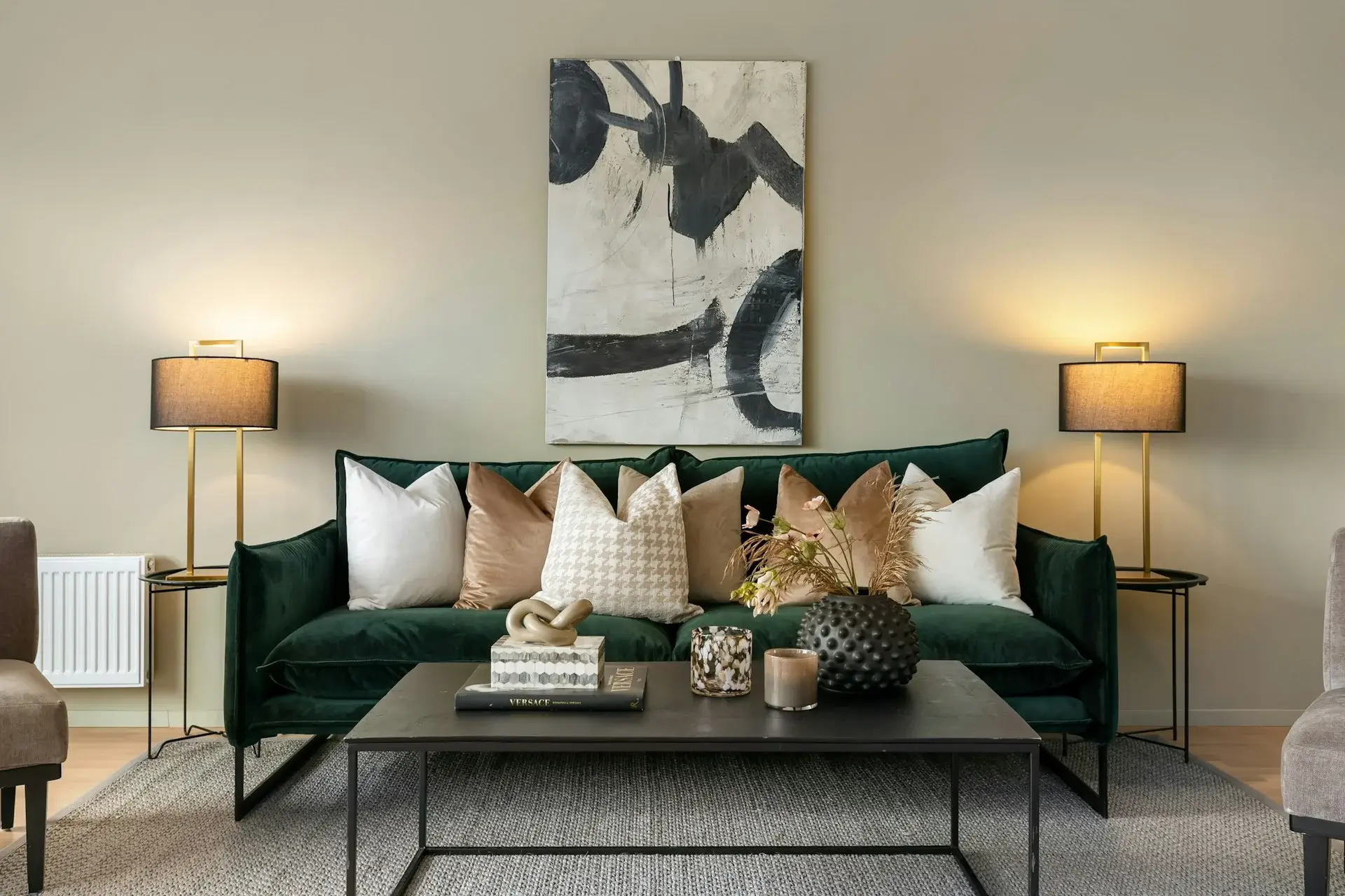 Modern kitchen with gray cabinets, built-in oven, black countertop, light backsplash, and indoor plants.