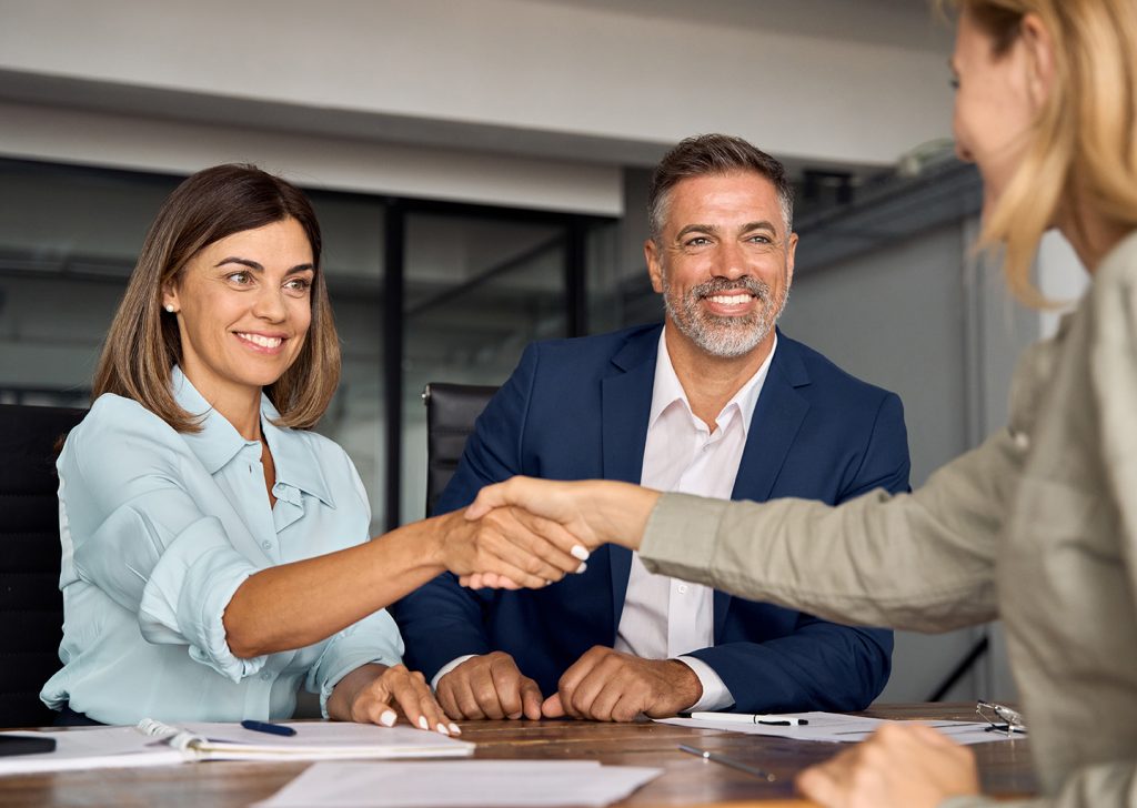 Firma di un contratto di lavoro a tempo indeterminato tra datoridi lavoro e dipendente, in un ufficio moderno