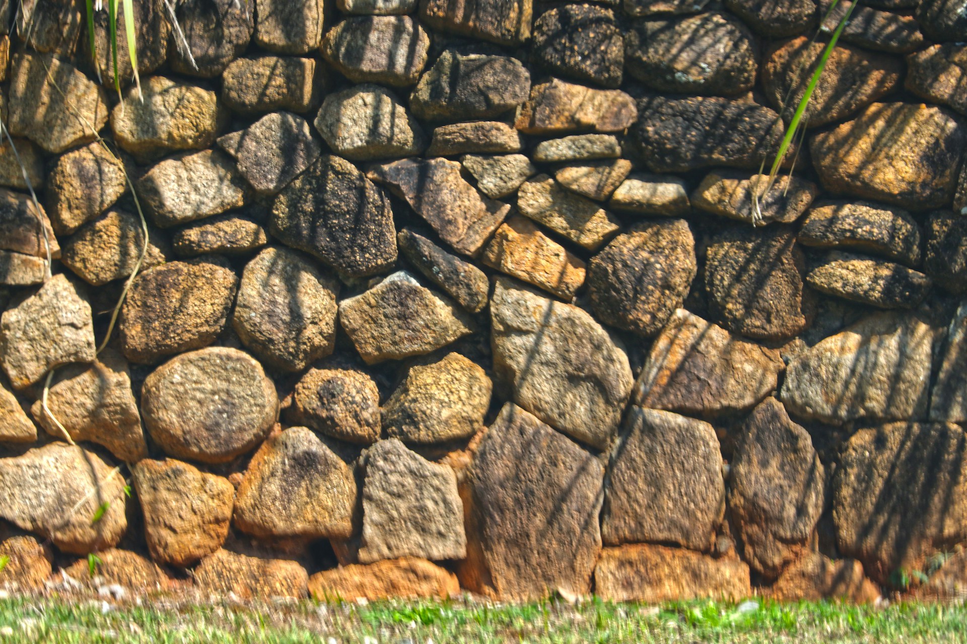 Mur de soutènement en pierres naturelles empilées de différentes tailles et textures.